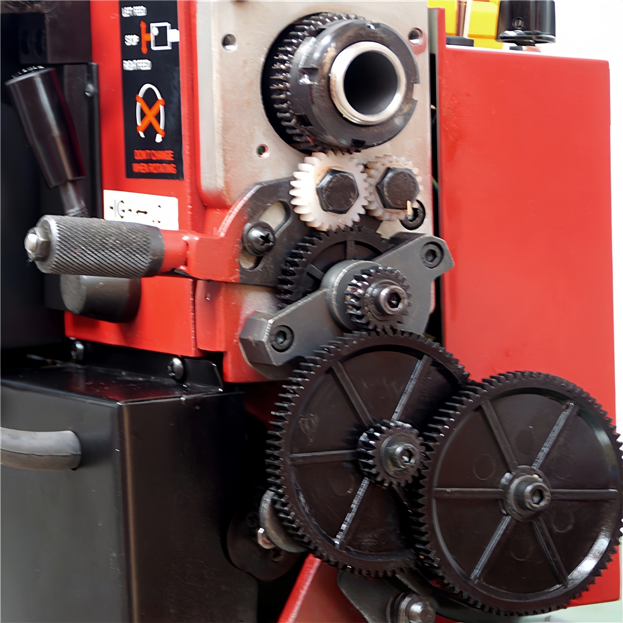 Close-up of a red and black industrial machine with exposed gears, metal components, and a black handle, photographed against a dark background. A watermark reading 'Ausee Machines & Tools' appears at the bottom.
