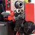 Close-up of a red and black industrial machine with exposed gears, metal components, and a black handle, photographed against a dark background. A watermark reading 'Ausee Machines & Tools' appears at the bottom.