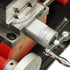 Close-up of a metal precision adjustment assembly with a silver cylindrical dial, engraved measurement markings, and a silver handle on a red and machined metal machine base.