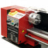 A red metal lathe machine with a clear protective guard, silver metal worktable, and black control panel labeled 'METALWORKER'.