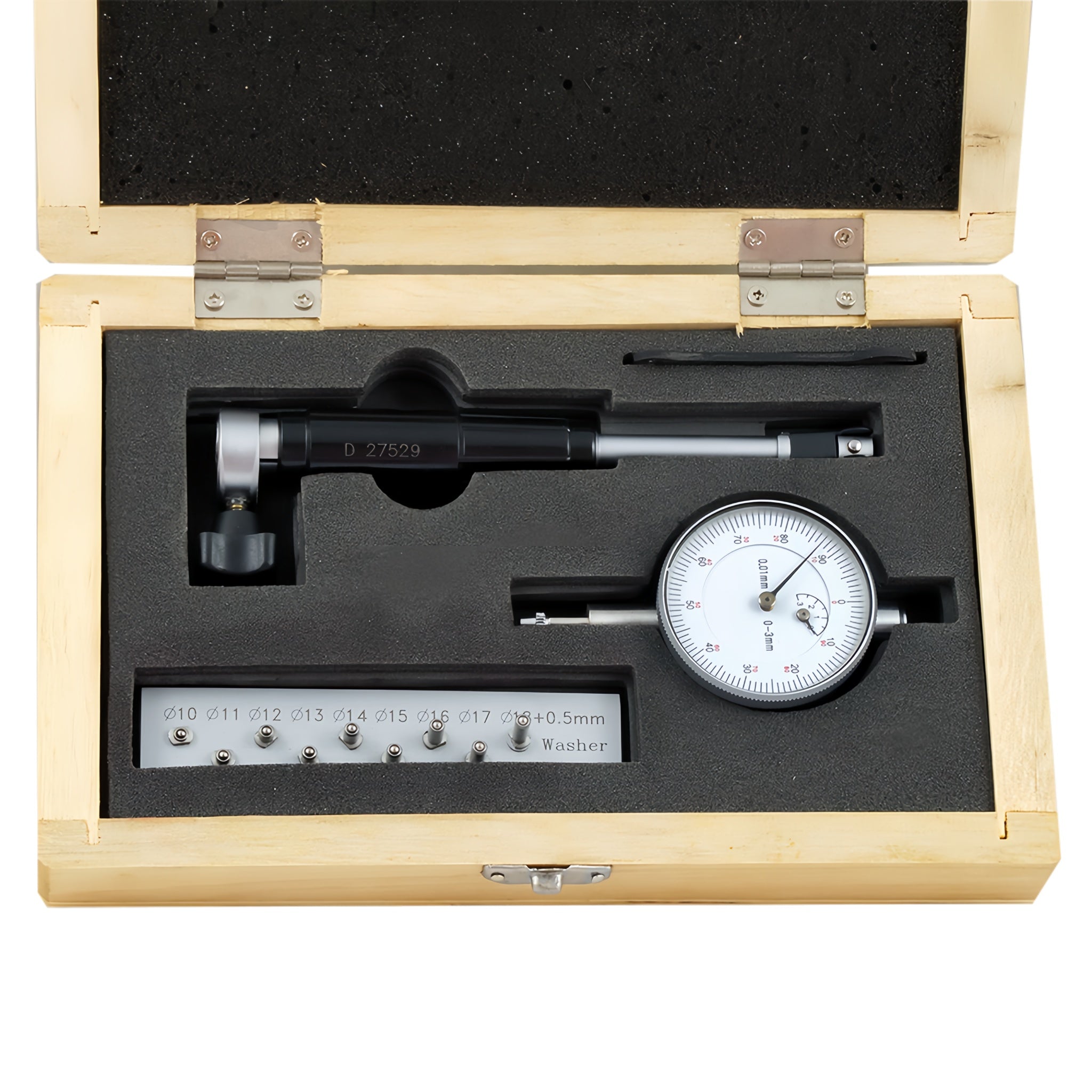 A precision dial indicator set inside an open light wood presentation box with black foam insert. The set includes a dial indicator, a caliper-like measuring tool, a small ruler scale, and a black pointer.