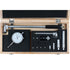 A precision dial indicator and measuring tool kit displayed inside an open wooden presentation box with black foam inserts. The kit includes a dial indicator, a long measuring rod with a black handle, several metal collars and adapters, small wrenches or screwdriver bits, and other small hand tools, all arranged neatly on a white background.