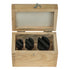 Three black fly cutters with angled tabs, displayed inside a light natural wood box on a plain white background.