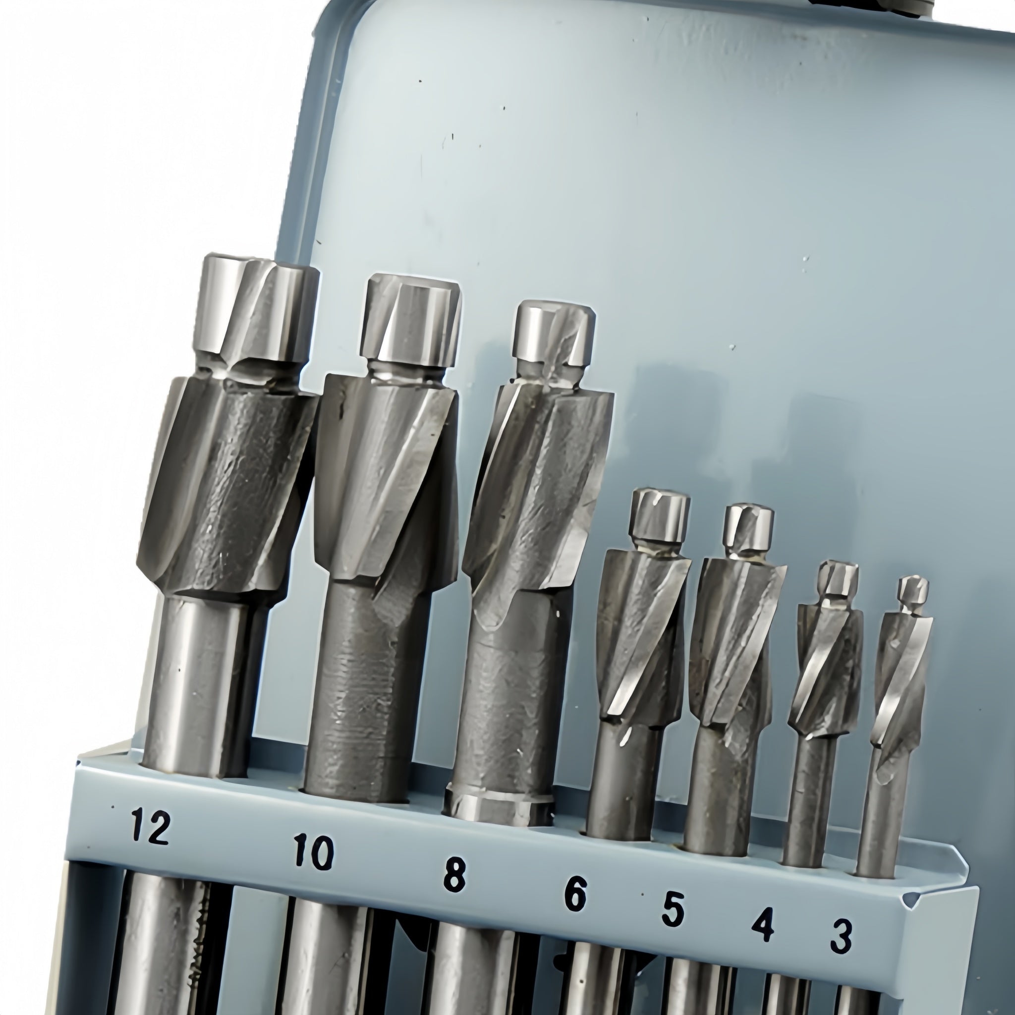 A set of metal counterbore in different sizes, numbered 12, 10, 8, 6, 5, 4, and 3, displayed in a light blue holder against a pale blue background.