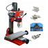 Red and black vertical drill press machine with a silver T-slot table, shown with several metal drill bits, a blue accessory holder, and mounting pieces on a white background.