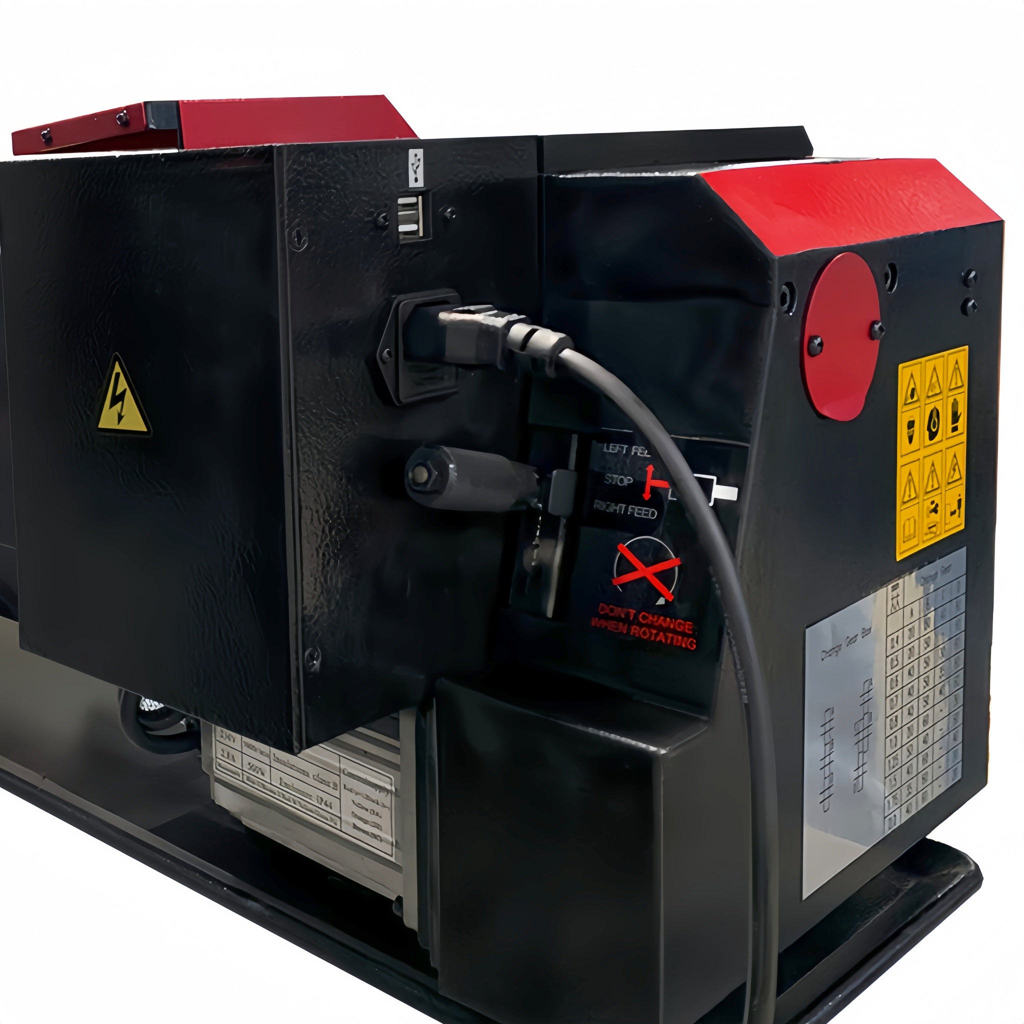 A close-up of a black industrial machine or equipment housing with red panels, warning labels, a power cord plugged in, and a small control switch on a white background.