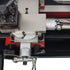 Close-up of a precision mechanical dial with silver metal components, red adjustment blocks, and white measurement scales on a black base.