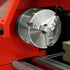 Close-up of a silver metal lathe chuck mounted on a red machine, with visible SANQU branding on the chuck body.