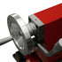 Close-up of a red and silver metal machine component with a large circular dial and adjustment screw, shown on a white background.