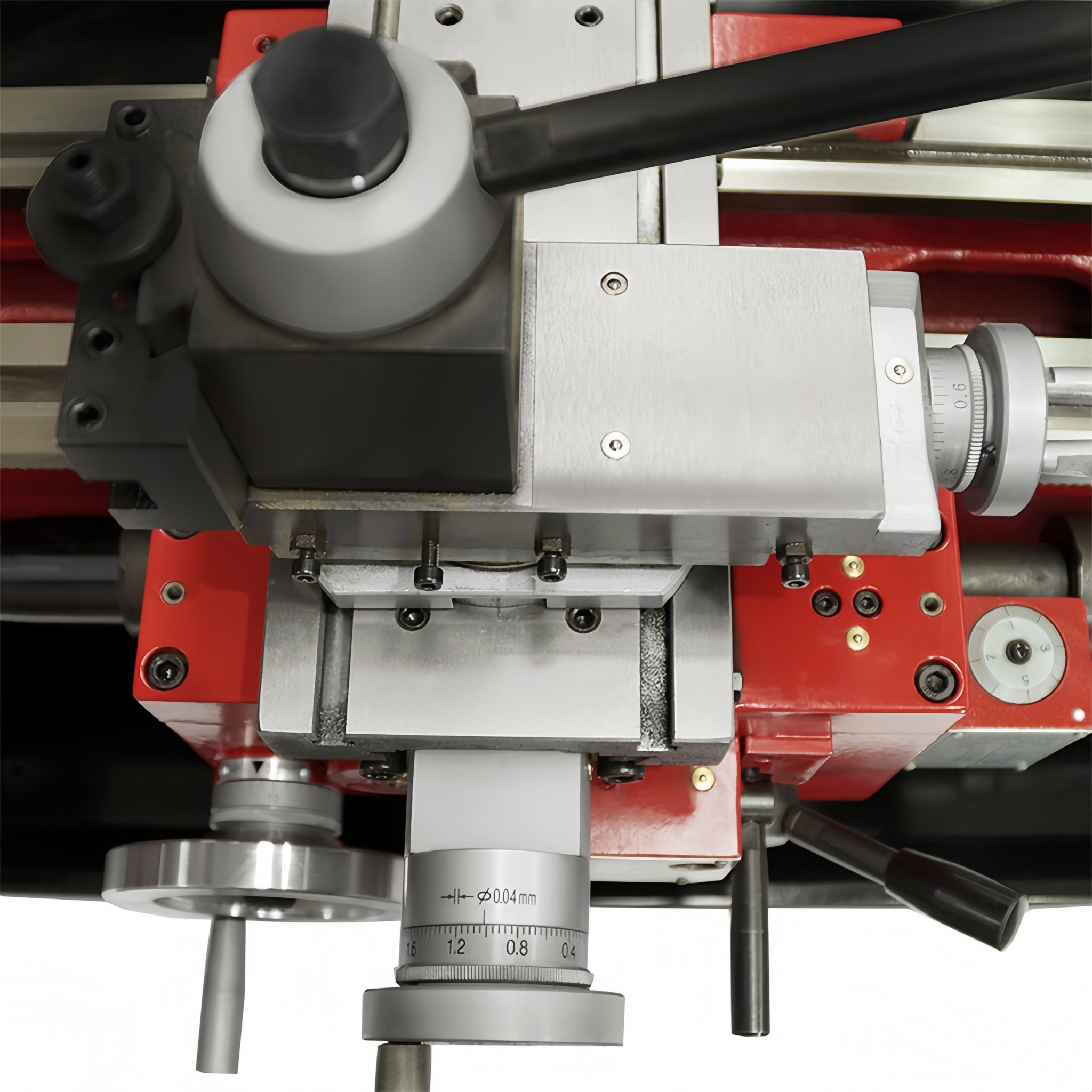Close-up of a machine spindle head and carriage assembly with silver metal components, black knobs, and a red machine body on a white background.