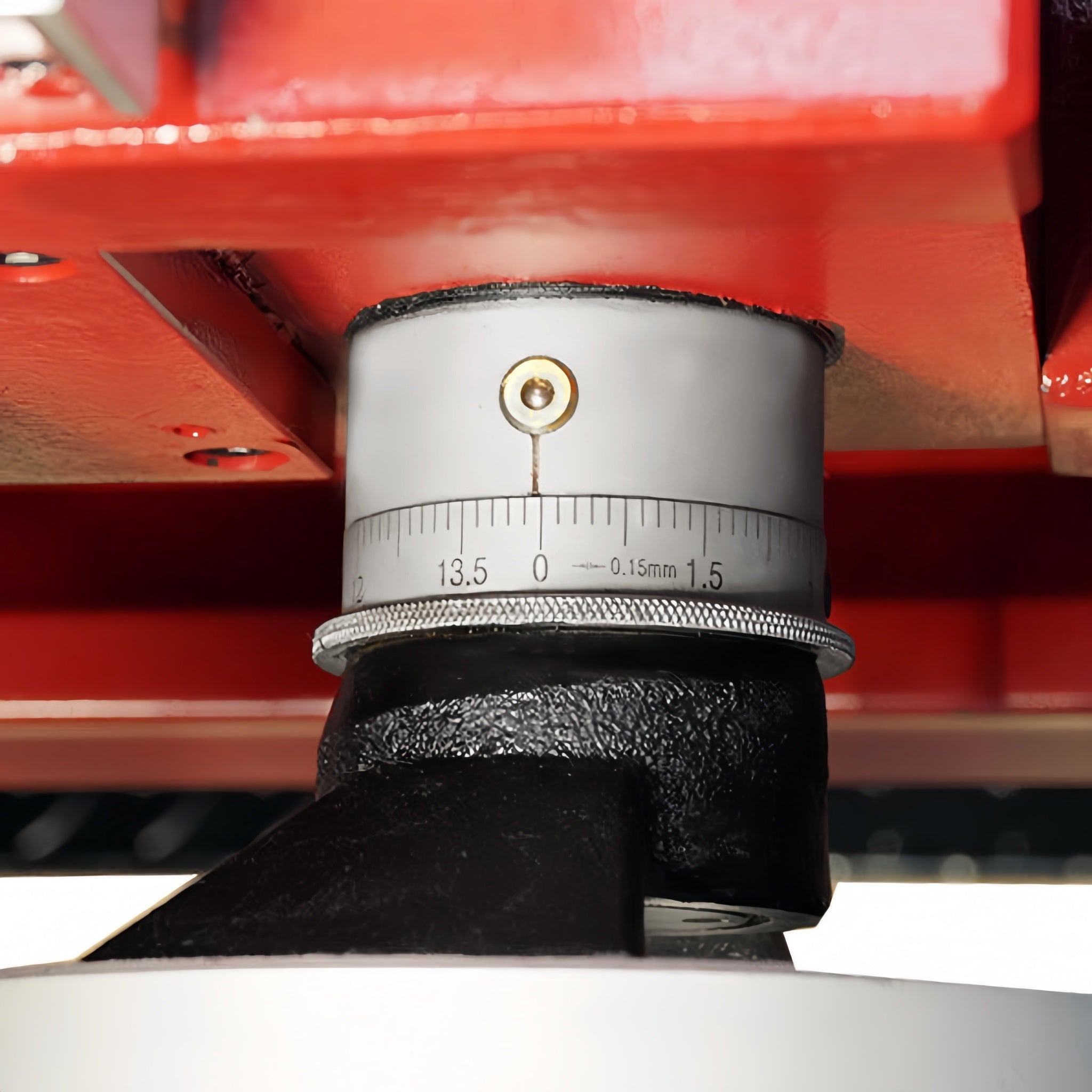 Close-up of a mechanical component with a scale on a red background