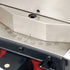 A close-up of a metallic three-claw lathe chuck mounted on a red industrial machine body.