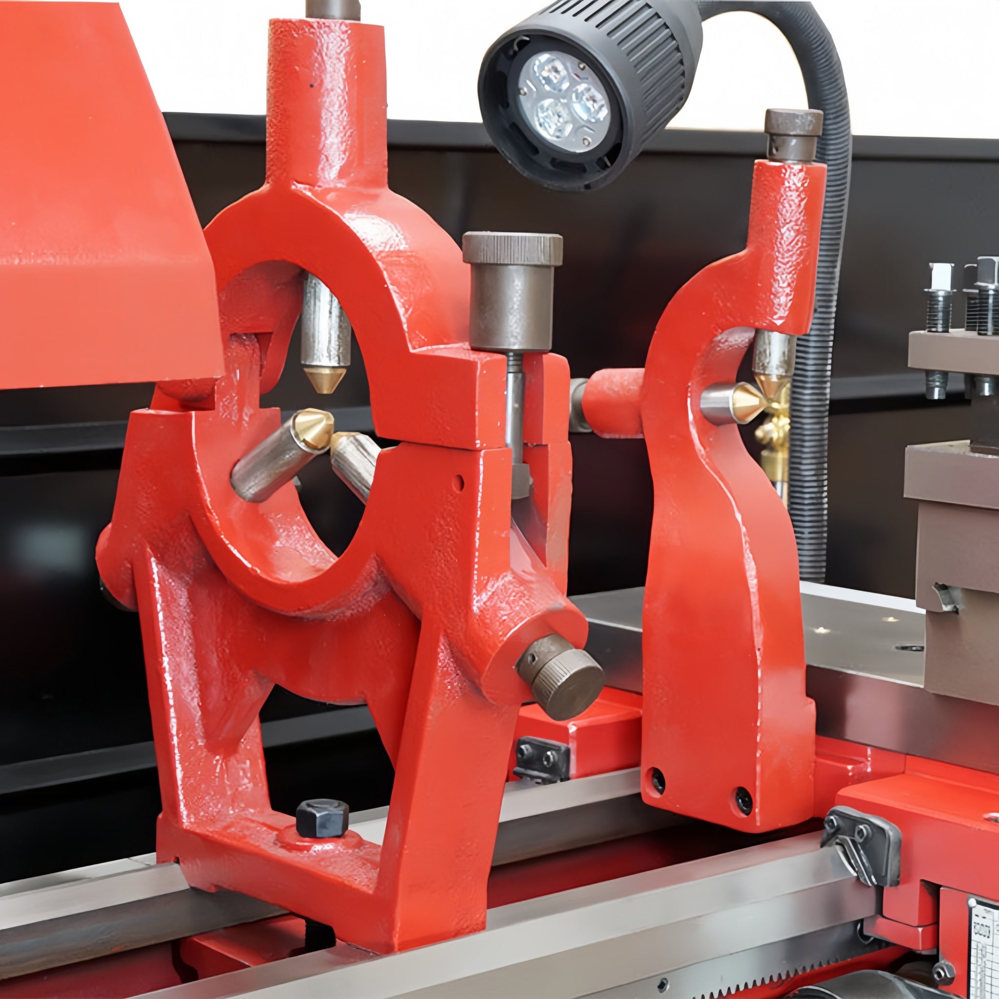 Red metal lathe machine with a close-up view of its components.