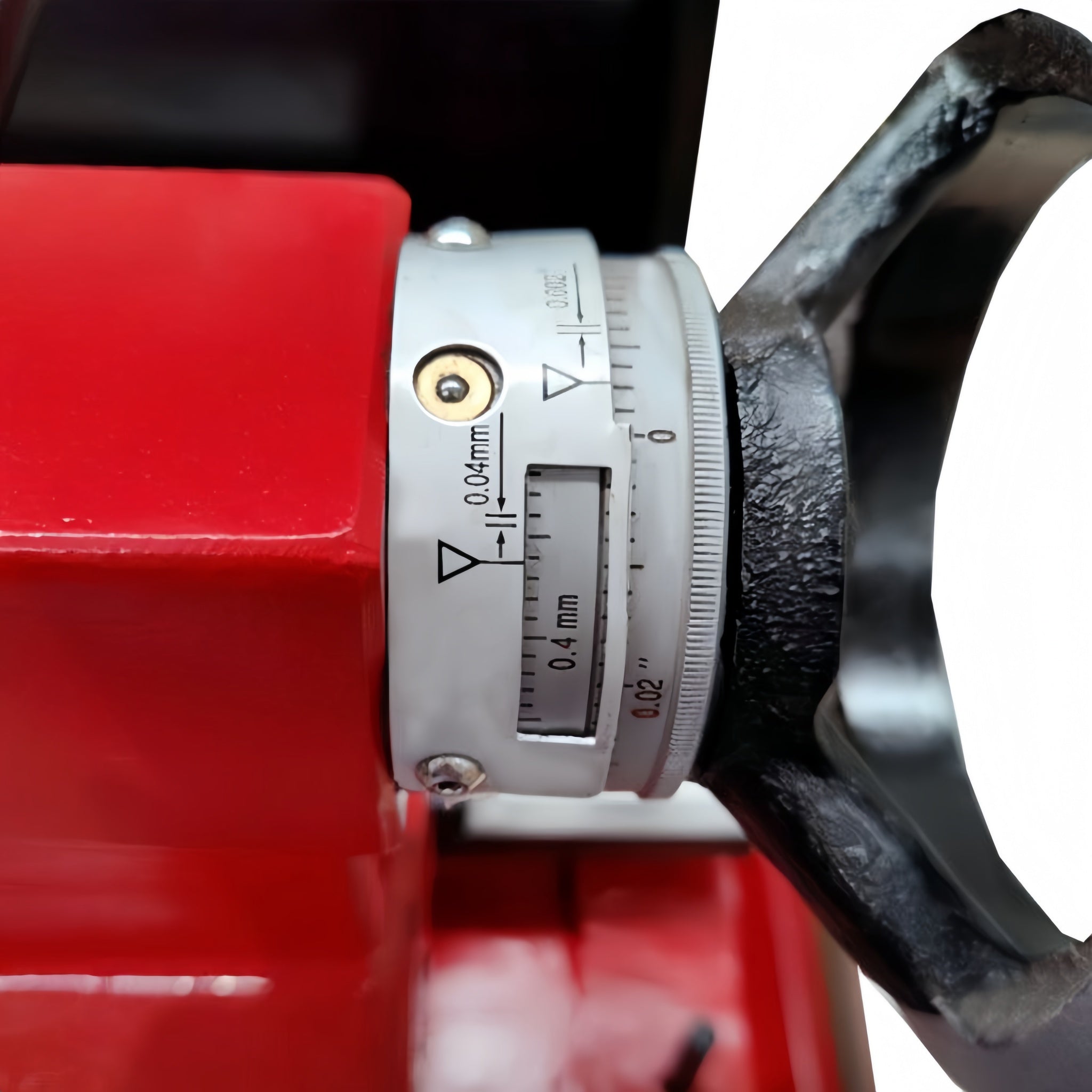 Close-up of a red lathe tailstock with a metal component featuring measurement markings.