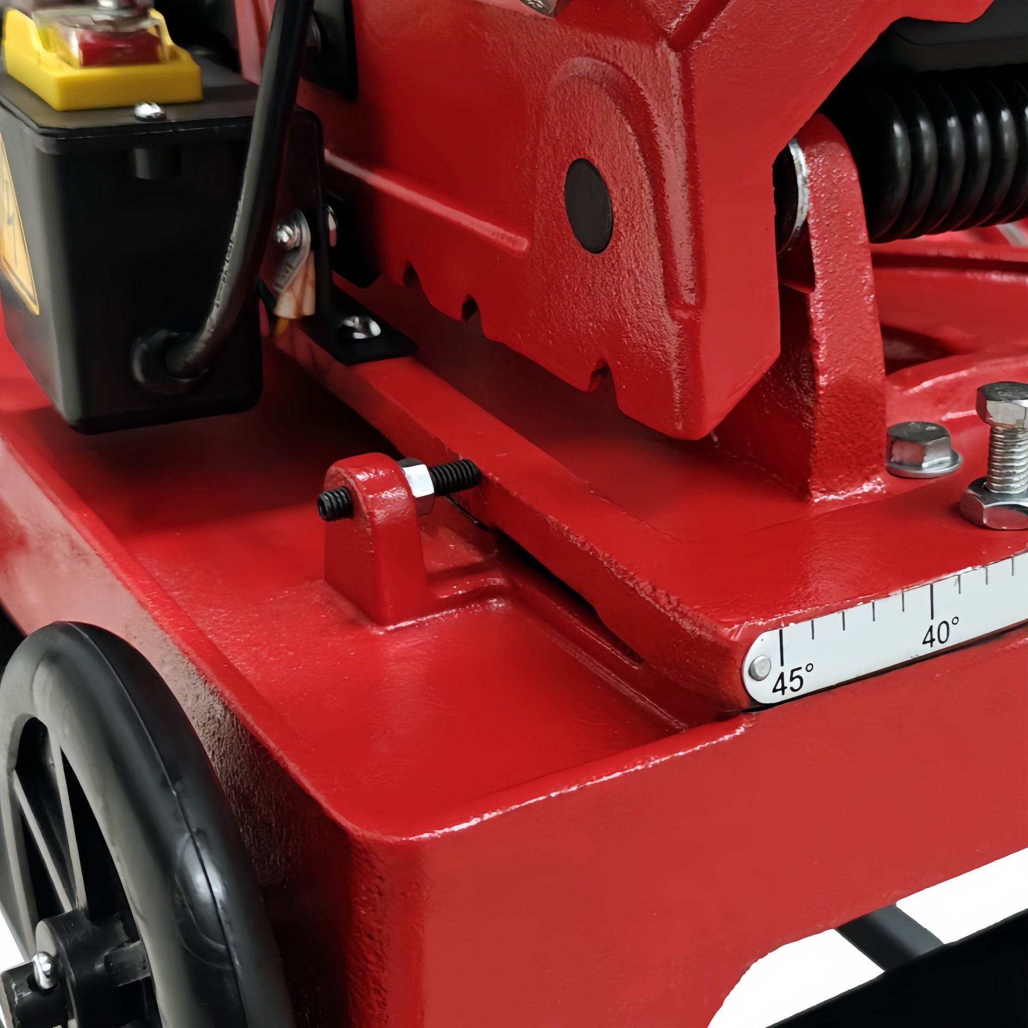 Close-up of a red metalworking machine with a scale on a white background