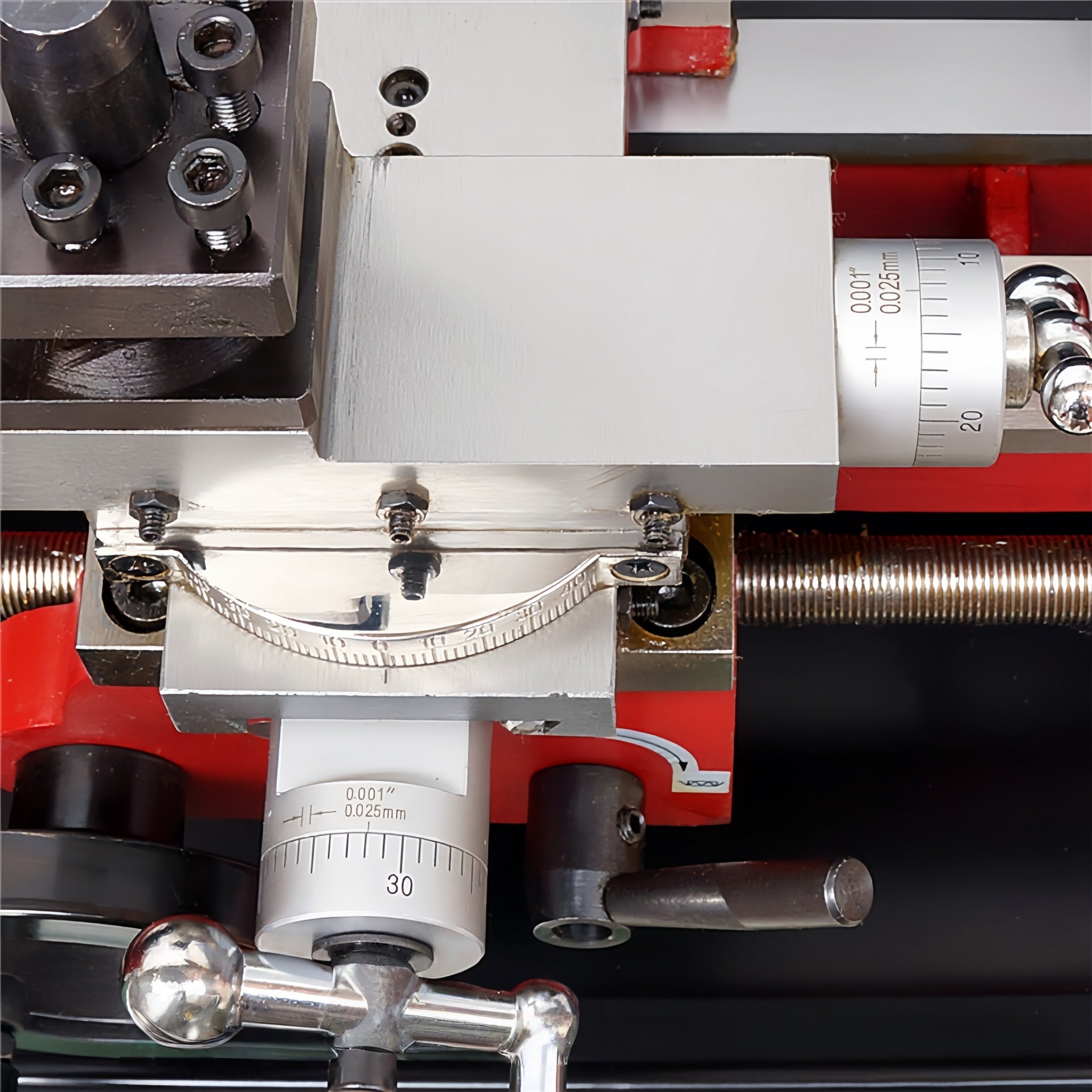Close-up of a precision mechanical tool or machine component with silver metal parts, red housing, threaded rods, and white measurement scales. A watermark reading 'Musc Machines & Tools' appears across the bottom.