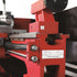 Close-up of a red industrial machine component with a black curved hose, metal rails, and a white label reading 'Induction harden bedway'.