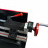 Close-up of a black and silver metal lathe machine tailstock and DRO with red accents, including a red-handled lever, a red wheel, and a small digital display on a white background.